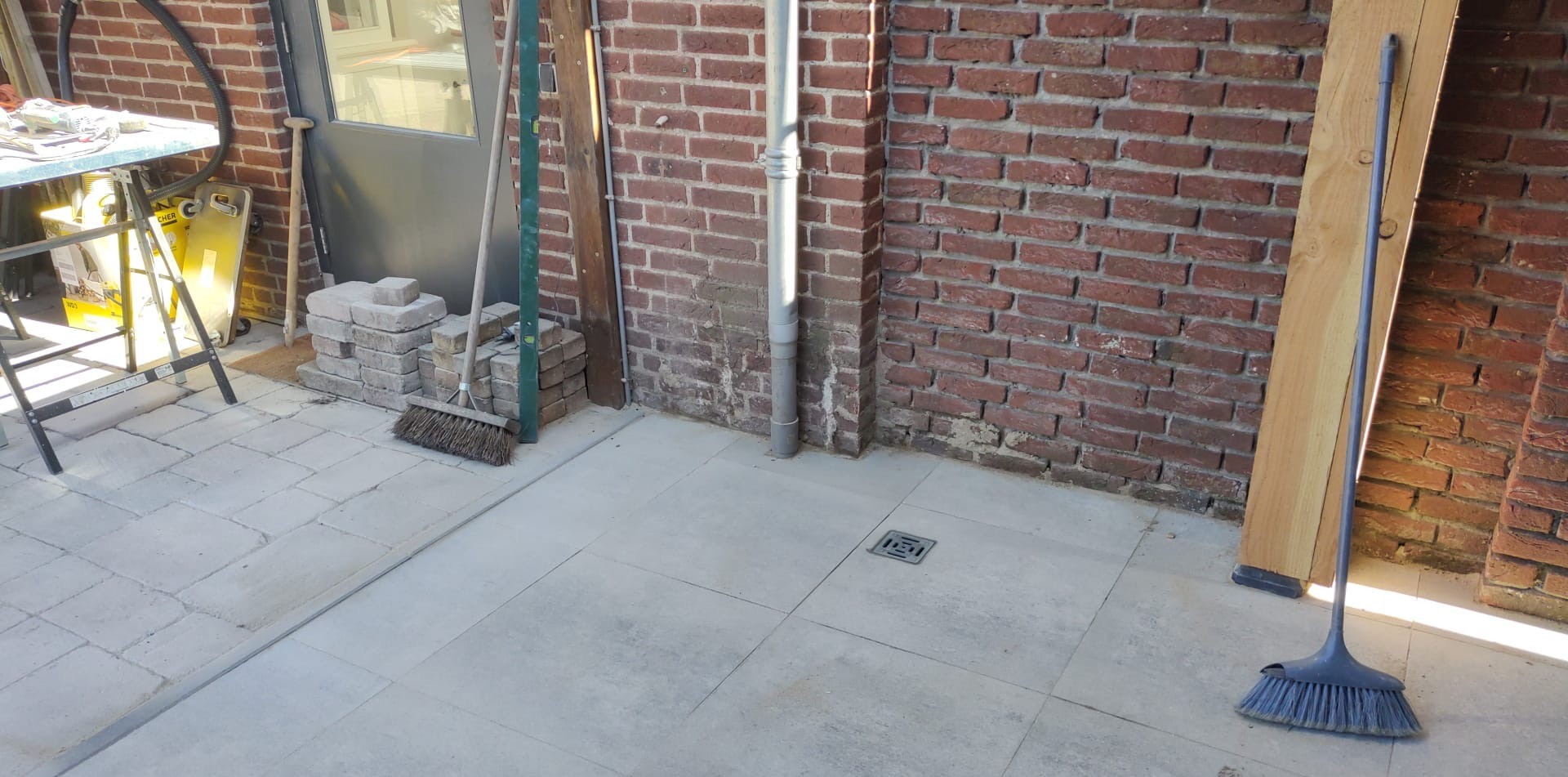 Netjes gelegde keramische terrastegels tegen de gevel