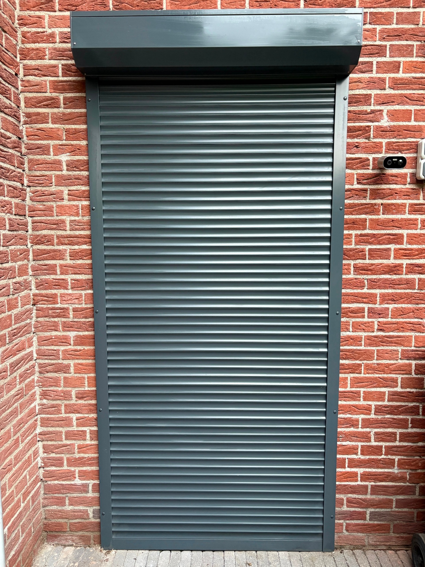 Hoog rolluik geplaatst naast een garage