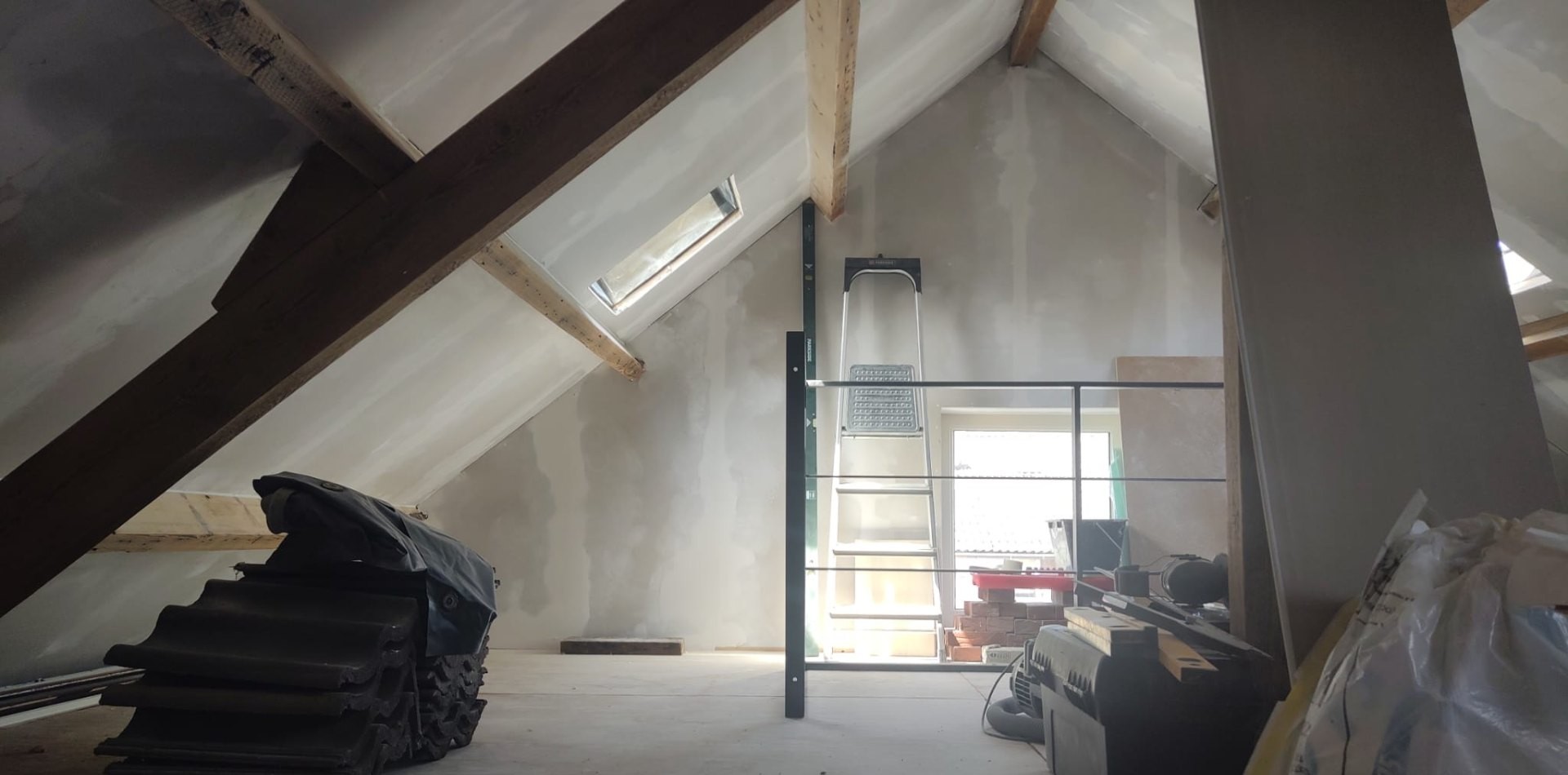 Zolder in aanbouw met dakbalken en dakramen