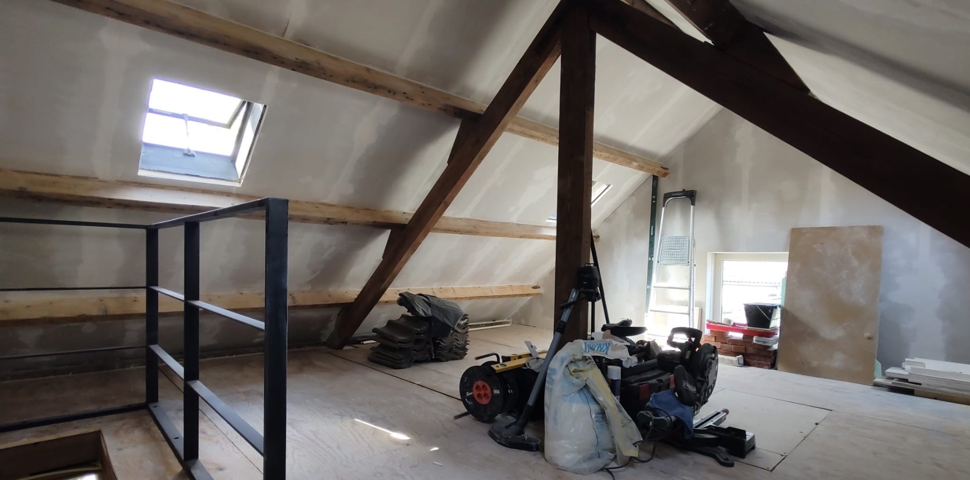 Zolder met dakbalken en dakraam tijdens de verbouwing
