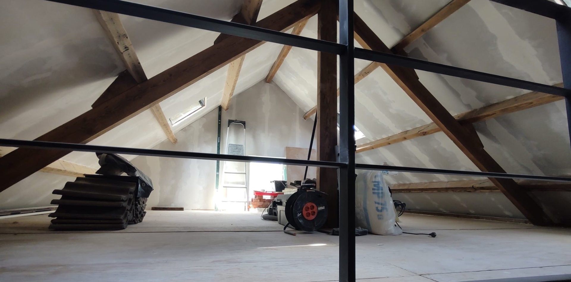 Zolder in aanbouw, gezien door een stalen taatsdeur